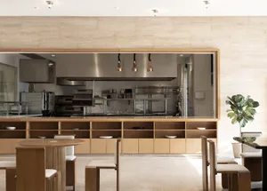 A dimly lit kitchen with wooden cabinets, multiple sinks, and various appliances, creating a cozy atmosphere