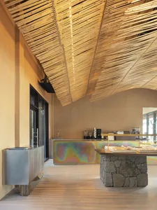Warm and inviting restaurant interior with wooden floors and walls, featuring two sinks, cups, and bottles, creating a comfortable dining experience