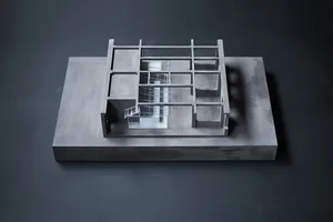 Black and white architectural model of a modern house with clean lines, minimalistic features, and visible concrete and metal materials