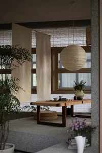 Cozy dining space with a wooden table, chairs, and decorative elements including vases and potted plants