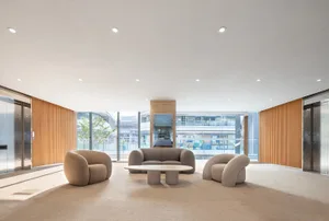Open living area with a large couch, chairs, dining tables, and a mounted TV, creating a comfortable and inviting atmosphere