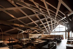 Warm and inviting restaurant interior with wooden floors, tables, and chairs, surrounded by multiple dining areas and benches