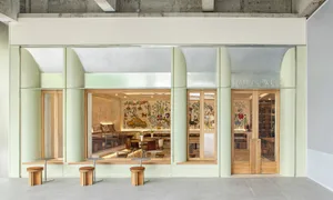 A modern cafe with artwork on the walls, comfortable seating, and natural light pouring in through a large window