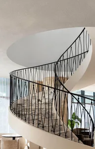 A real photo of a modern staircase with metal stairs, surrounded by walls with decorative elements and artwork, conveying a sense of elegance and luxury