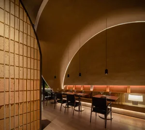 Elegant dining space with a large circular table, wine glasses, and wood elements
