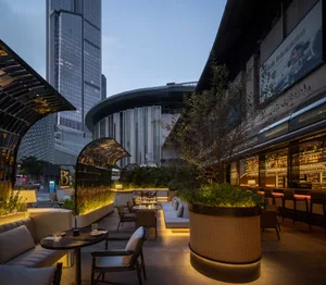 A well-lit lobby with a modern design, featuring chairs, couches, wood, and metal, creating a comfortable atmosphere for socializing