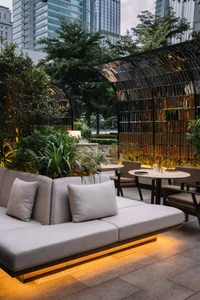 A well-lit living space with a couch, chairs, dining table, and potted plants, encouraging conversation and interaction among guests