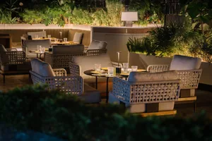 A dining area with a table surrounded by multiple chairs, some with cushions, creating a cozy atmosphere for social gatherings