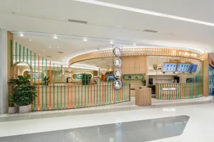 A modern hotel lobby with a circular design, decorative clocks, and potted plants, featuring a welcoming atmosphere and modern style