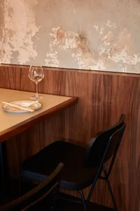 Warm and inviting dining area with a wooden table, black chair, and dinner settings