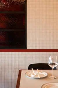 A cozy dining area with a wooden table and chairs, wine glasses, and serving spoons