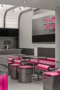 A modern restaurant interior with pink chairs and tables, a black and white color scheme, and a comfortable atmosphere