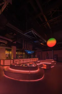 A cozy bar lounge with a circular table surrounded by chairs and couches, creating a relaxed atmosphere for socializing and leisure time
