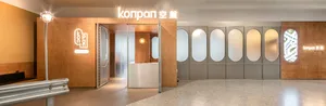A well-lit Asian bathroom with a wooden door and two sinks, one on each side of the door