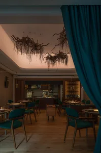 Warm and inviting restaurant interior with wooden floors and tables, and comfortable seating for guests