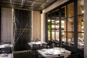 Elegant dining space with wooden tables, wine glasses, and well-lit surroundings