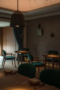 An inviting restaurant interior with multiple dining tables, wood paneling, and tiled walls, featuring comfortable seating and warm lighting