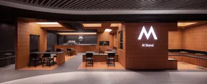 A warm and inviting cafe with wooden floors and walls, featuring multiple tables and chairs, potted plants, and a cozy atmosphere