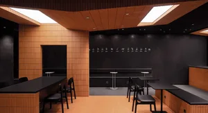 A modern restaurant with a black and white color scheme, wooden walls, and lighting fixtures, featuring a large dining table and several chairs