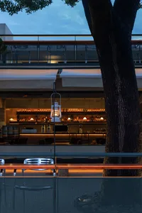A cozy bar area with a wooden counter and chairs, featuring a well-stocked display of bottles