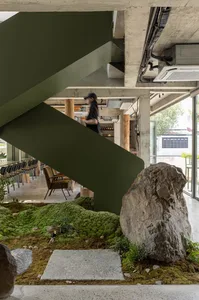 Inviting cafe with a staircase, chairs, and a potted plant, creating a comfortable atmosphere for guests