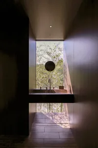 A well-lit bathroom with two sinks, one with a mirror above, under a window, with a clean and organized atmosphere
