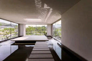 A modern indoor pool area with a staircase, potted plants, and a focus on relaxation and leisure