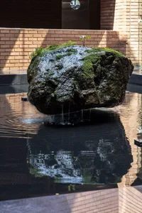 室內泳池區中央置有大型岩石，周圍環繞水池，營造悠閒氛圍
