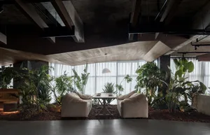 A well-decorated living area with a couch, dining table, and potted plants, creating a cozy atmosphere