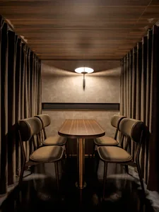 A wooden dining table surrounded by four chairs in a cozy residential dining area with a warm atmosphere