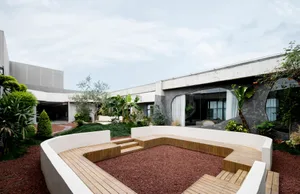 Architectural rendering of a building's exterior featuring a patio with potted plants and a bench, creating a welcoming and relaxing atmosphere