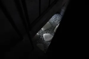 A darkened room with a doorway and rocks on the ground, creating a cozy and intimate atmosphere