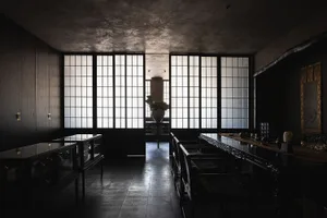 燈光柔和的現代餐廳，以黑白主題為主，設有大型餐桌與座椅，營造溫馨氛圍