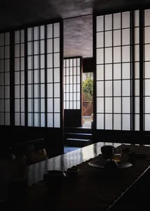 A classic and elegant dining area with a wooden table, chairs, and decorative vases, set against a black and white background