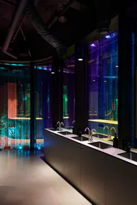 Modern bathroom with two sinks under a large window, black marble countertops, and a well-lit atmosphere