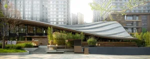 A city building with multiple levels and potted plants on the facade and ground level, adding a lively atmosphere