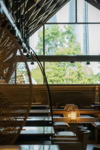 A restaurant interior with multiple dining tables and chairs, creating an inviting atmosphere for socializing and meals