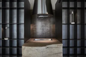 Modern kitchen with a large stainless steel sink built into a stone countertop, featuring a marble sink and minimalist design