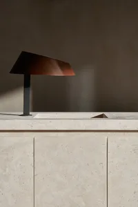 A modern room with a wooden lamp on a marble countertop, set against a white-painted wall
