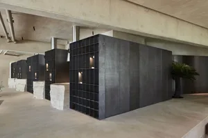 Industrial interior with a metal wall, concrete floor, black bookshelves, and cement walls, giving a modern and minimalist feel