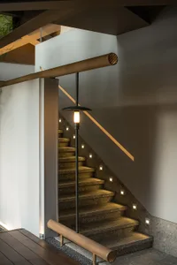 A traditional staircase with stone steps leading to a landing in a dimly lit building