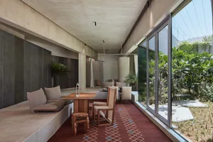 Cozy open concept living space with a red carpet, two couches, chairs, and a dining table, creating a warm and inviting atmosphere