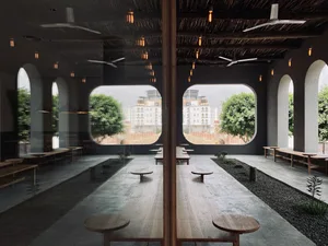 A well-designed indoor dining area with wooden tables and chairs, natural light from large windows, and a cozy atmosphere