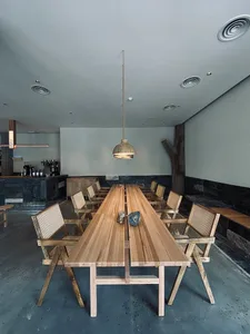 A dining area with a wooden table and chairs, surrounded by clean lines and minimalistic decorations, lit by natural light