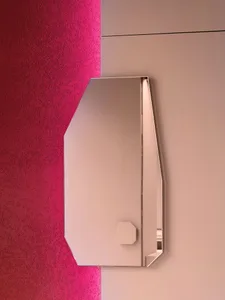 A pink wall in front of a bathroom mirror reflects a red wall behind it, creating a visually interesting effect in a well-lit bathroom