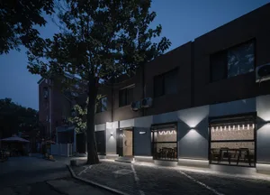 A restaurant at night with a brown exterior, dining tables, and chairs creating a cozy atmosphere for patrons