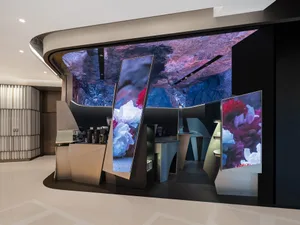 Elegant interior design showroom featuring a large display of flowers in vases on tables and the floor, with a focus on beautifully arranged floral displays