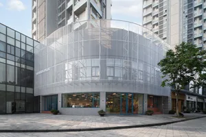 Contemporary building with a large glass dome, concrete exterior, and interior greenery