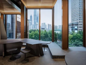 Modern lobby with a large window offering a city skyline view, featuring two dining tables and four chairs
