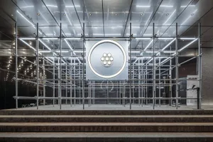 A modern interior space with a large white circle on the wall, surrounded by a glass exterior that allows natural light to enter, creating a bright and airy atmosphere